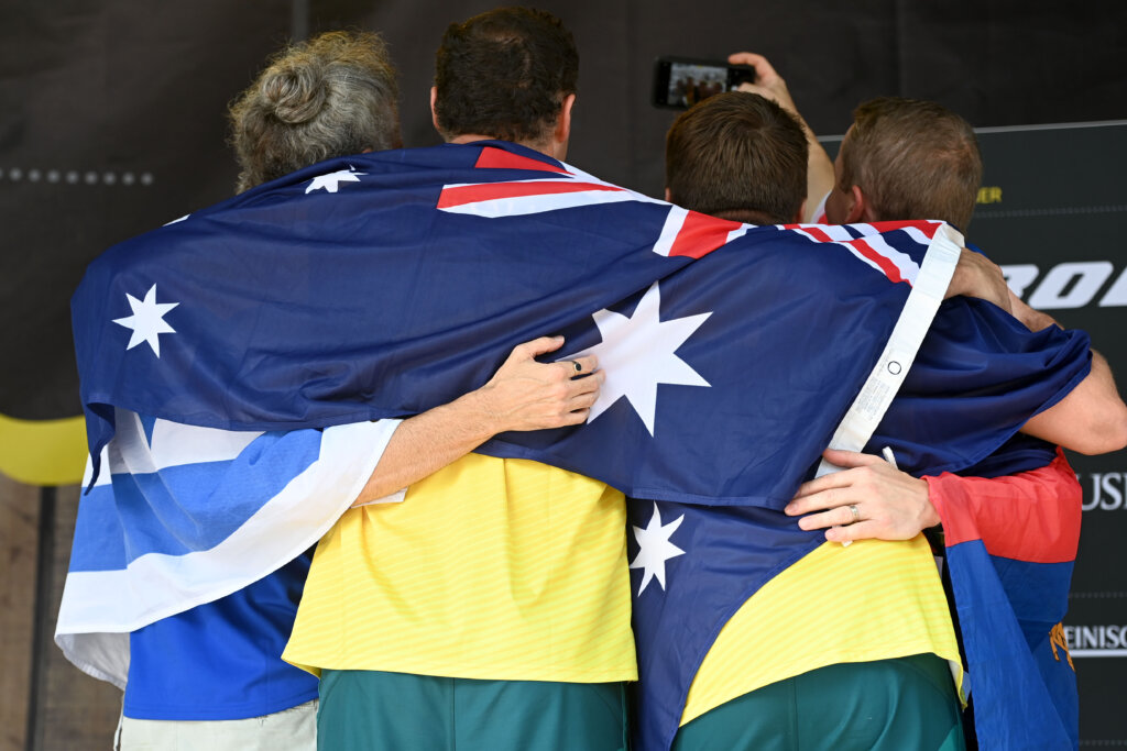 Invictus Games Dusseldorf 2023 Team Australia members embrace between the Australian Flag