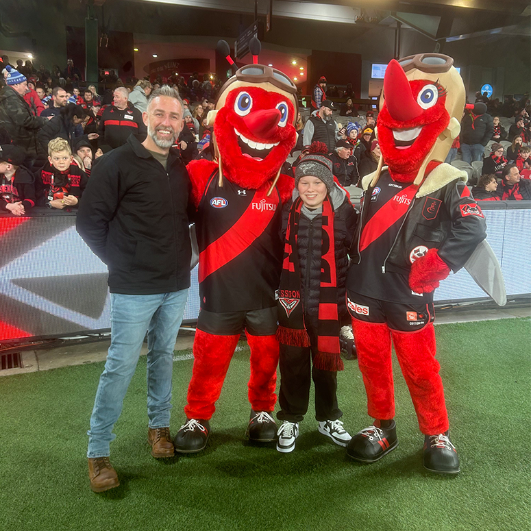 Veteran and family member with the Essendon mascots