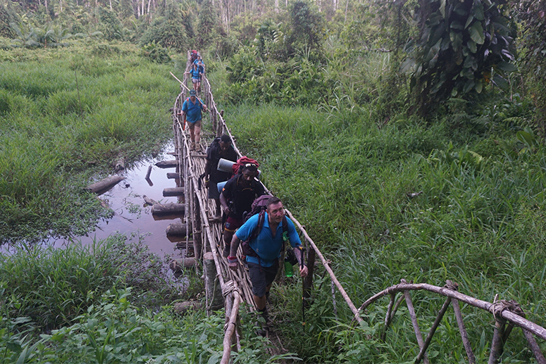 Kokoda trek group heads across a bridge