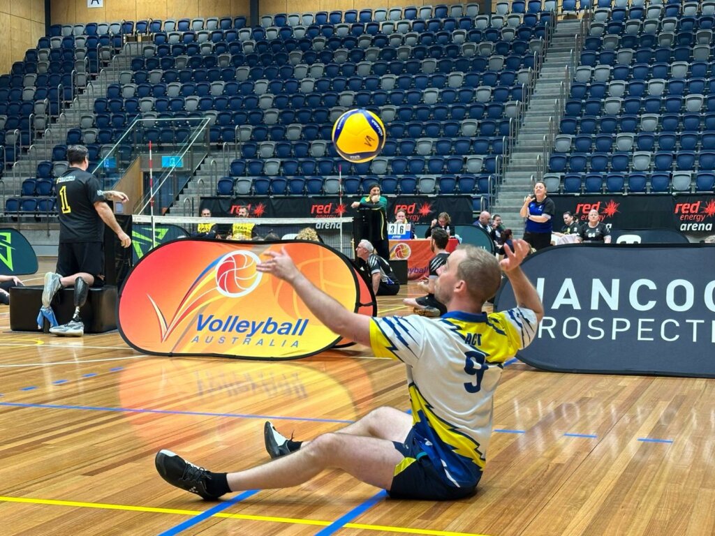 Invictus Games Team Australia train on contingent at the sitting volleyball championships competitor serves